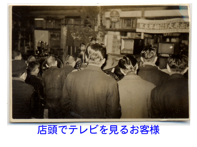 店頭でテレビを見るお客様の画像